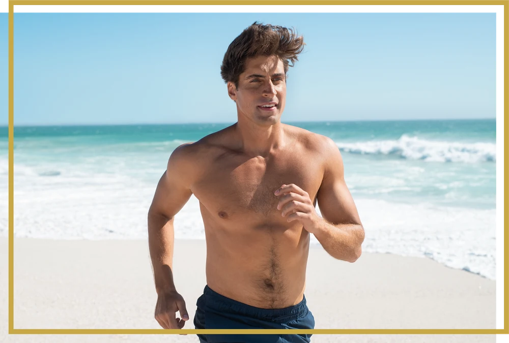 happy fit man running on beach after testosterone therapy